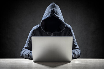 Computer hacker stealing data from a laptop - 493922901