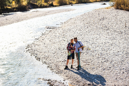 Austria, Alps, couple on a hiking trip standing at a brook
