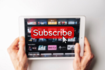 Subscription plan. Red online video subscribe button. Internet service on laptop digital tablet blured technology background. Visual contents concept. Social networking service.