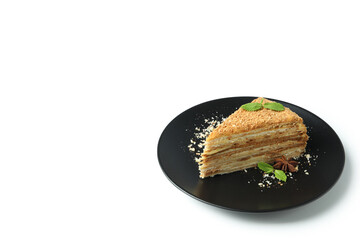 Plate with piece of honey cake isolated on white background