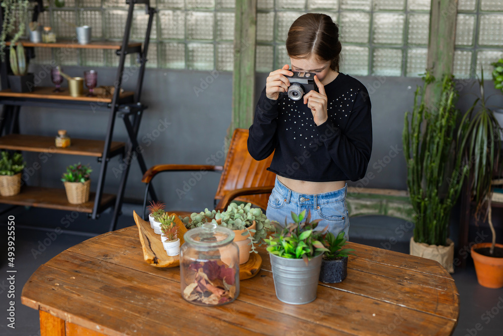 Wall mural girl taking pictures of her houseplants 