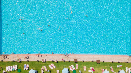 aerial view of people resting sunbathing near city pool