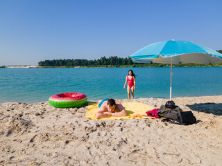 couple at sandy beach sunbathing swimming