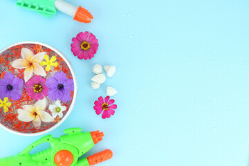 Top view of bowl of water , water gun and chalk powder on blue