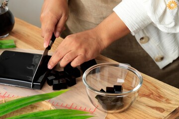Obraz na płótnie Canvas Female Homemaker Cut Cincau Hitam or Black Grass Jelly Pudding into Pieces, Healthy Food
