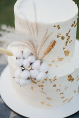 Stylish modern wedding cake. Beautiful delicious dessert decorated with fresh flowers and greenery.