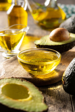 Oil and ripe fresh avocado on rustic wooden table