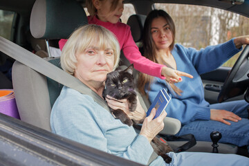 Family of Ukrainian refugees, seniors, woman and kids, fleeing from war against Russia and cross...