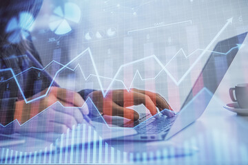 Double exposure of businesswoman hands typing on computer and forex graph hologram drawing. Financial analysis concept.