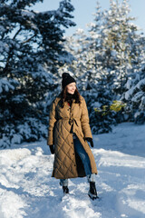 Smiling woman walks in forest in sunny winter day.