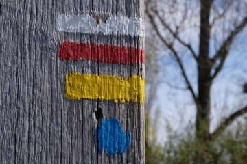 Balisage d'un itinéraire de randonnée peint sur un support en bois