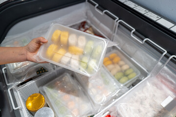 A pair of hands that choose food in the fridge