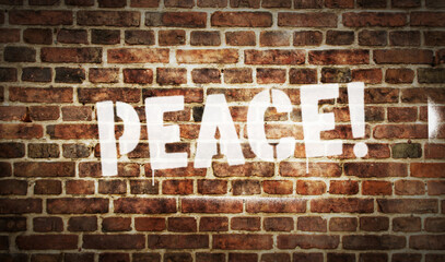 Peace spray painted inscription on the brick wall