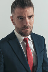middle aged businessman with beard in elegant suit looking away