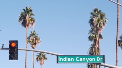 Palm trees and blue sky, Palm Springs resort city near Los Angeles, street road sign, semaphore traffic lights on crossroad. California desert valley summer road trip on car, travel USA. Indian Canyon