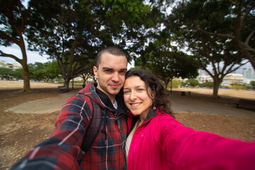 Happy young couple taking a hugging selfie together