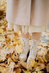 white boots against the background of autumn foliage