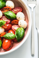 Caprese salad with tomatoes, mozzarella, basil and olive oil. Healthy mediterranean food concept. Close-up photography.