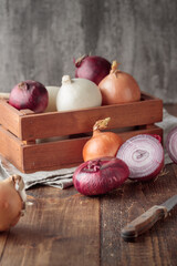 Different onions on a wooden background