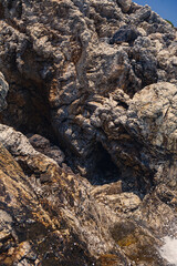 Waves with foam and splashing water. The wave crashes into the rocks on the shore