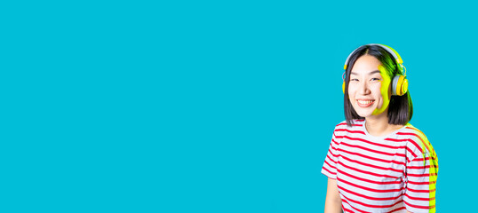 serene asiatic woman isolated on blue  background listening music