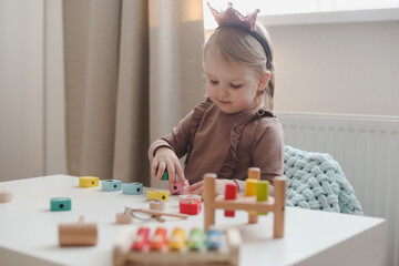  child playing and building with colorful wooden toys. Early learning and development