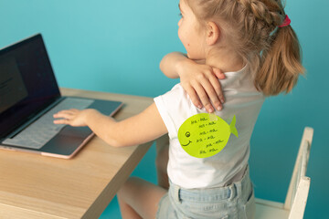 Little girl with joke sticker on back against blue background April fool's day. date 1 April