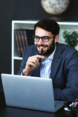 Ive got just the idea.... Cropped shot of a young businessman sitting in front of a laptop and thinking in a modern office.