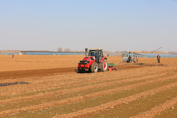 farmers drive planters to sow peas in fields in North China