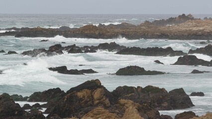 Rocky craggy pacific ocean coast, sea water waves crashing on rocks, 17-mile drive, Monterey California USA. Gloomy dramatic nature near Point Lobos, Big Sur, Pebble beach. Seamless looped cinemagraph