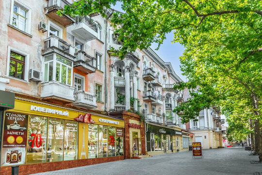 Mykolaiv, Ukraine - July 26, 2020: Old building with modern shops on Soborna street, 5 in Mykolaiv. Beautiful ancient architecture with decorative columns, balconies and stucco on a pedestrian street