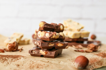 Pieces of tasty chocolate with nuts on table