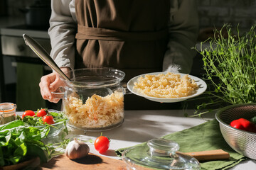 Woman with plate and cooking pot in kitchen