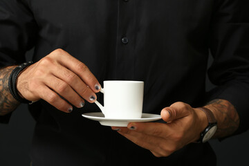 Male hands with trendy manicure holding cup of coffee, closeup