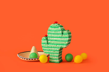 Mexican pinata in shape of cactus with sombrero hat and balloons on color background