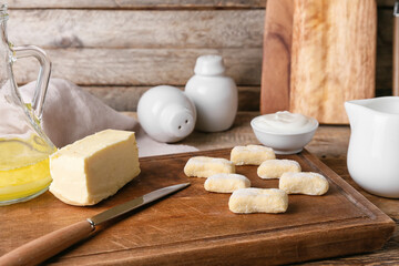 Board with raw lazy dumplings and products on wooden table, closeup