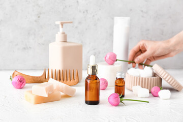 Set of bath supplies and rose flowers on light background