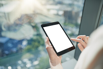 Time to check for important emails. Shot of a unrecognizable person browsing on a digital tablet with the city in the background.