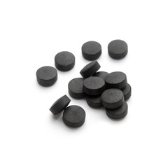 Heap of activated carbon pills isolated on white background