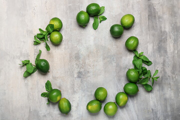 Frame made of fresh limes on grey background