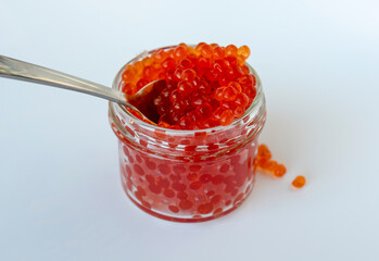 Red Caviar. Red fish caviar on a spoon in glass bowl. Raw seafood. Luxury delicacy food. 
