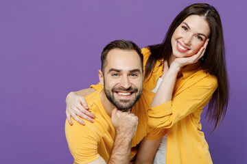 Fototapeta premium Young smiling happy fun nice lovely cheerful couple two friends family man woman 20s together wear yellow casual clothes looking camera hud cuddle isolated on plain violet background studio portrait