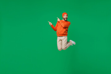 Full body young exultant happy overjoyed excited fun cool man 20s in orange sweatshirt hat jump...