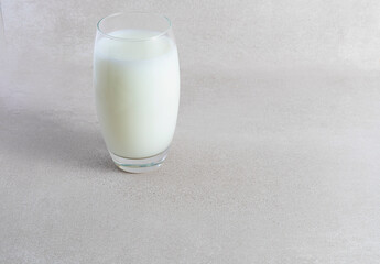 Glass of milk on light background