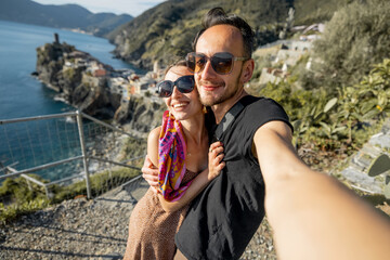 Selfie photo of couple on background of mediterranean coast in Italy. Traveling famous Cinque Terre region in northwestern Italy. Vernazza village