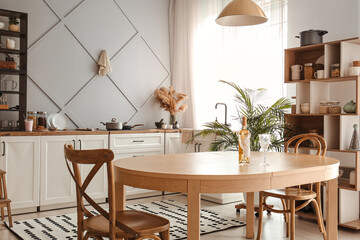 Bottle of wine and beautiful glasses on dining table in modern kitchen