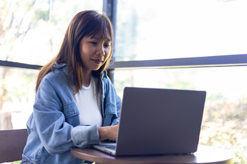 asian woman using laptop computer in cafe