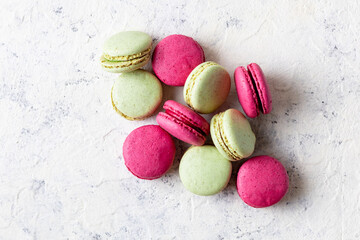 Pink and green macaroons on white background. Traditional French sweet dessert.