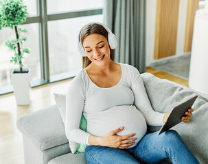 Obraz premium pregnant woman portrait mother female pregnancy belly young music headphone earphone listening sound maternity abdomen happy tablet computer happiness