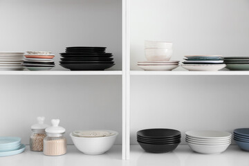 Shelf unit with set of clean dishes in kitchen
